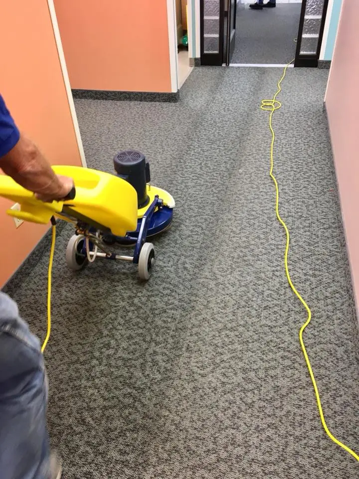 Cheyenne performing low-moisture commercial carpet cleaning in a Happy Valley office hallway