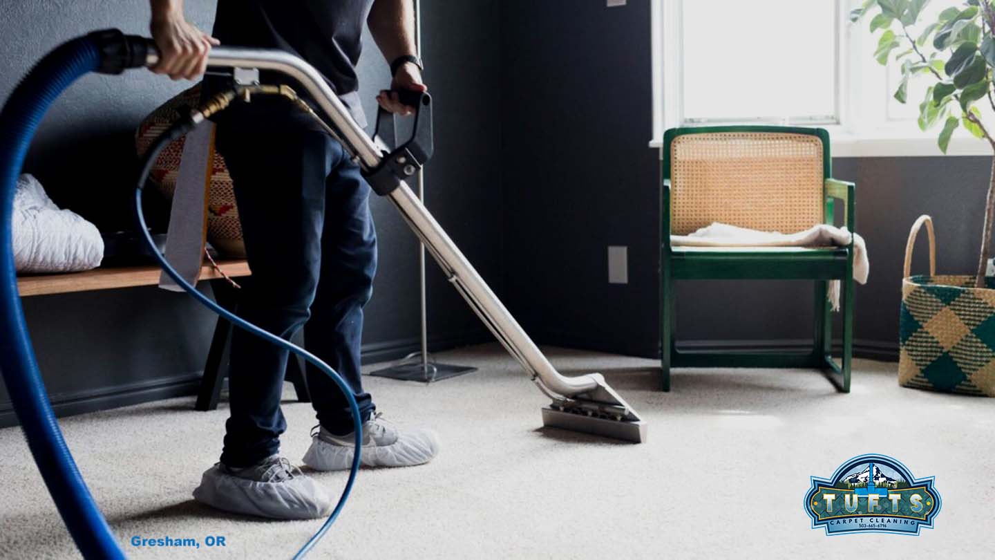 Professional carpet cleaning technician using truck-mounted equipment on residential carpet